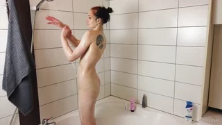 Redhead model Lea plays with oil in the shower room frame 10